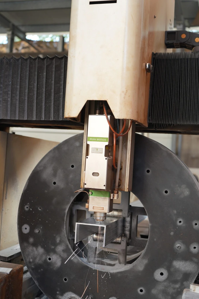 The beam laser cutting head in operation.